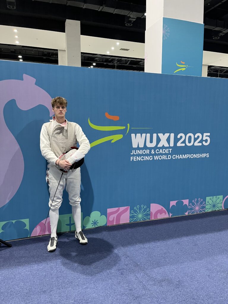 Šermíř stojící u loga Wuxi 2025